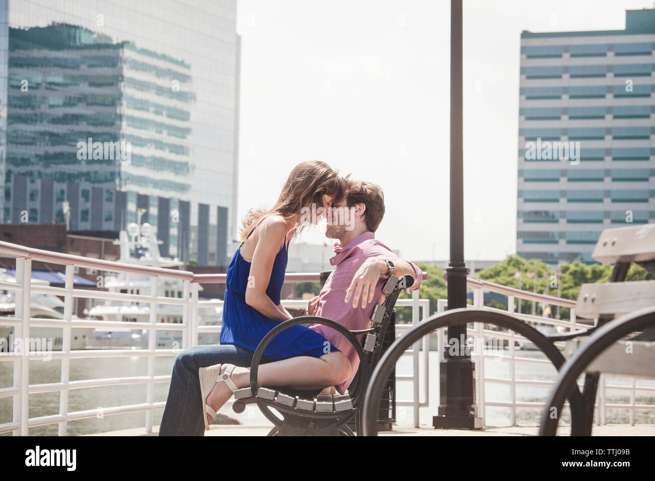 Romantisches Paar sitzt auf der Bank am Fluss Stockfoto
