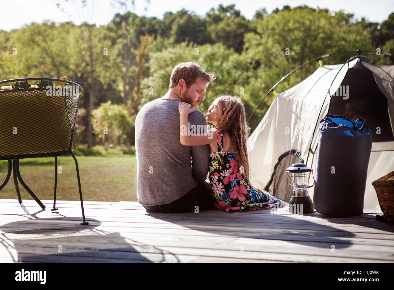 Hintere Ansicht von Vater und Tochter sitzen auf der Veranda in Rasen Stockfoto