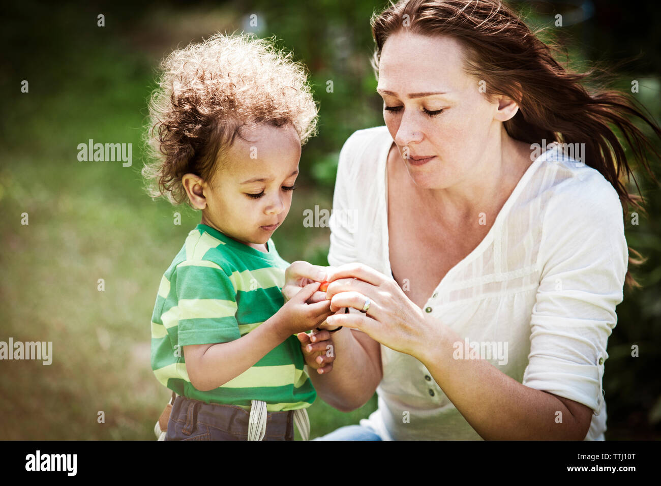 Mutter und Sohn mit Cherry Tomaten im Hinterhof Stockfoto