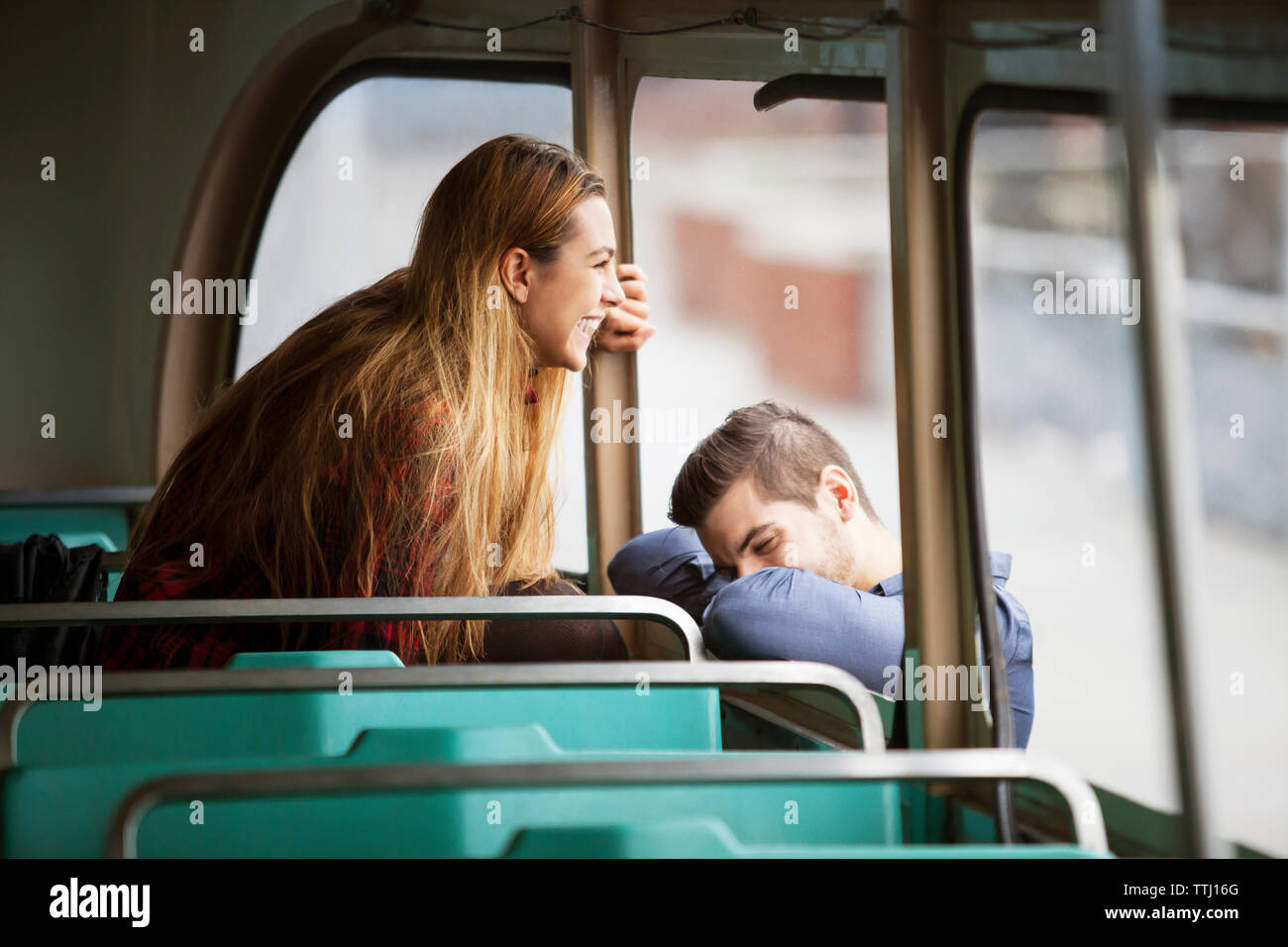 Glückliche Frau Blick durch Fenster, während man in der Straßenbahn gelehnt Stockfoto