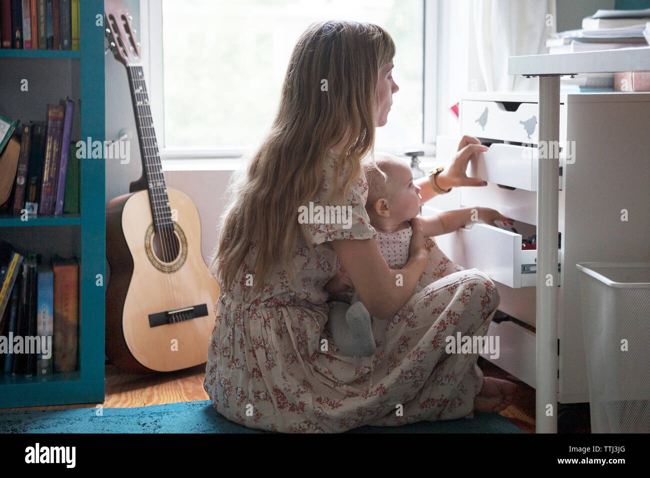 Mutter und Baby öffnen Schubladen zu Hause Stockfoto