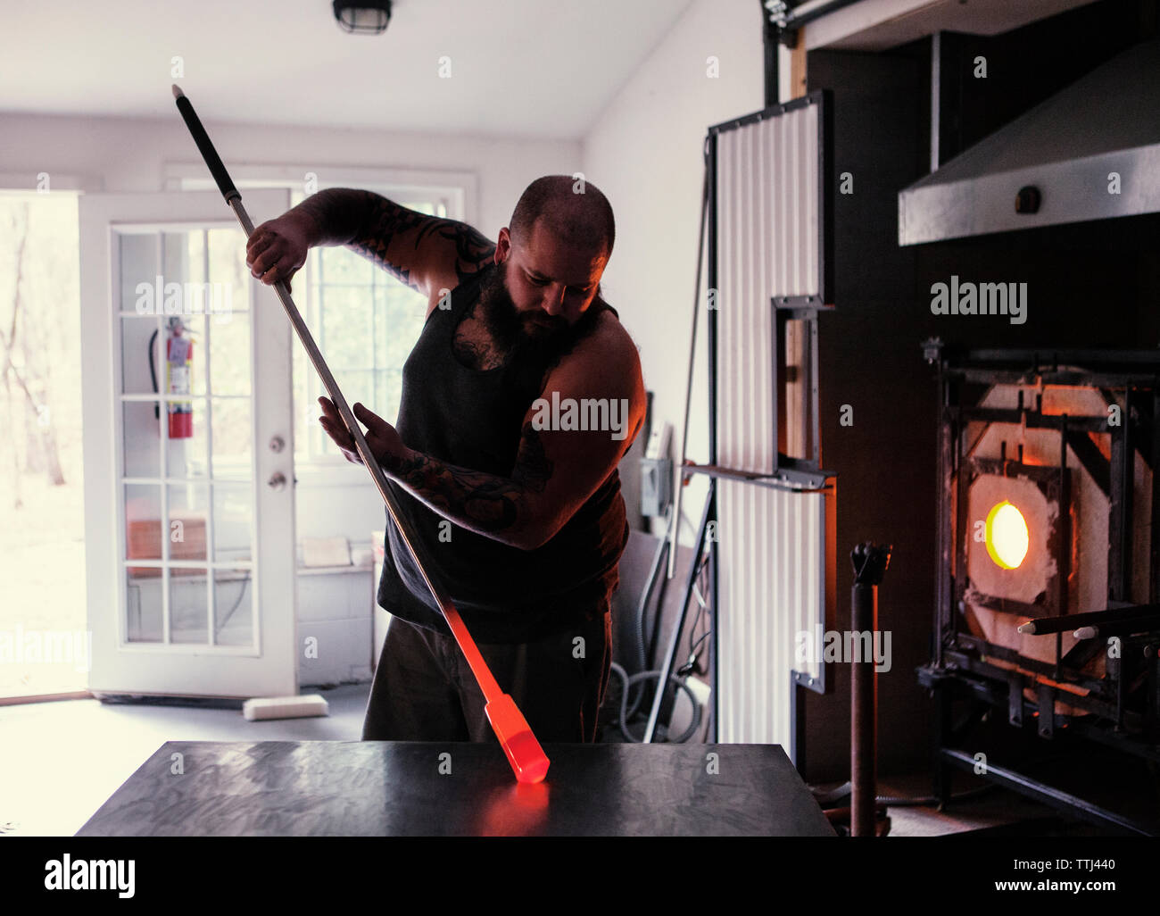 Glasbläser Holding blasrohr am Tisch in der Werkstatt Stockfoto