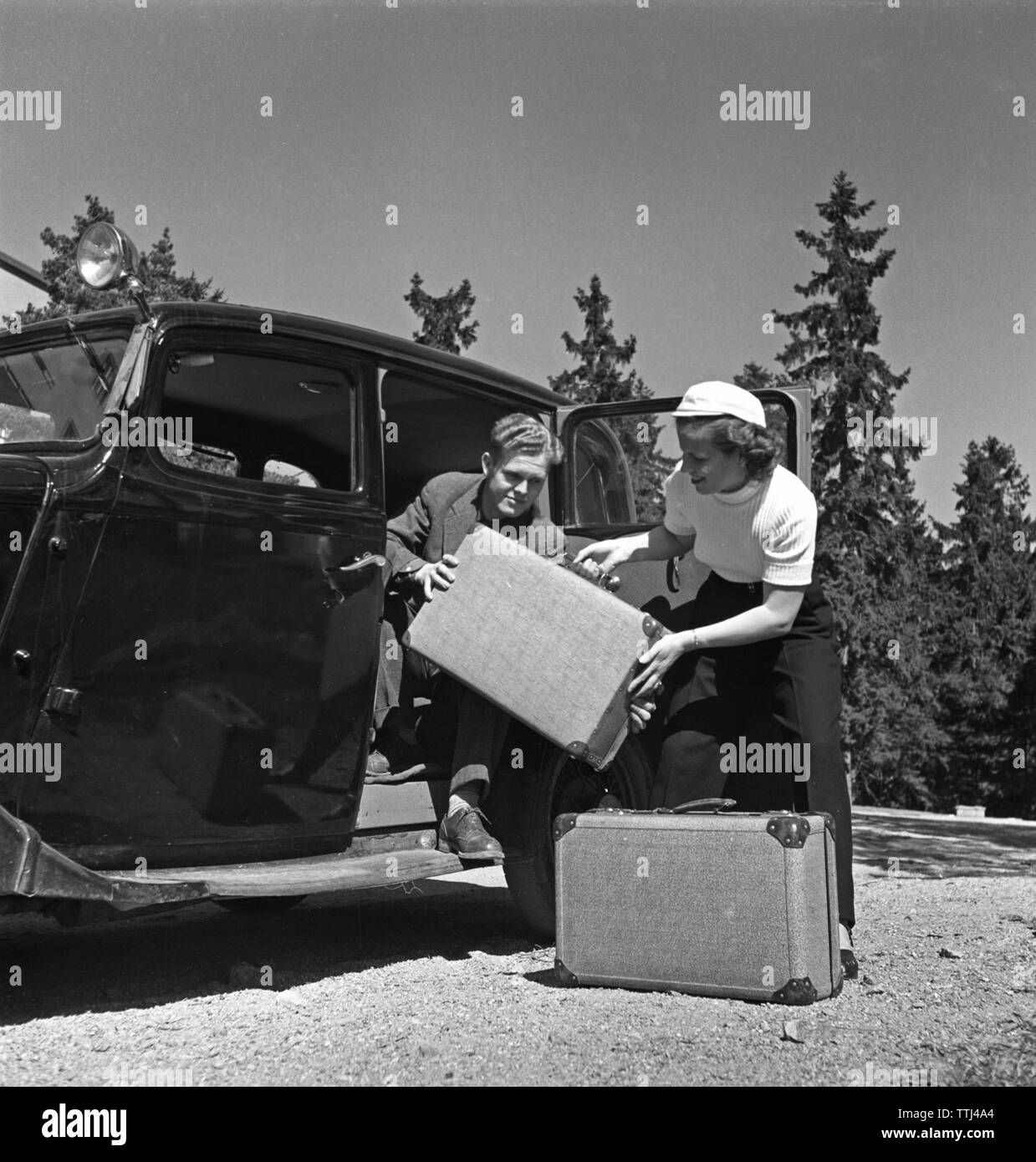 Paare, die in den 1950er Jahren. Ein junges Paar packen Ihr Gepäck für ein Auto Urlaub. Schweden 1952 Kristoffersson BF 76-10 Stockfoto
