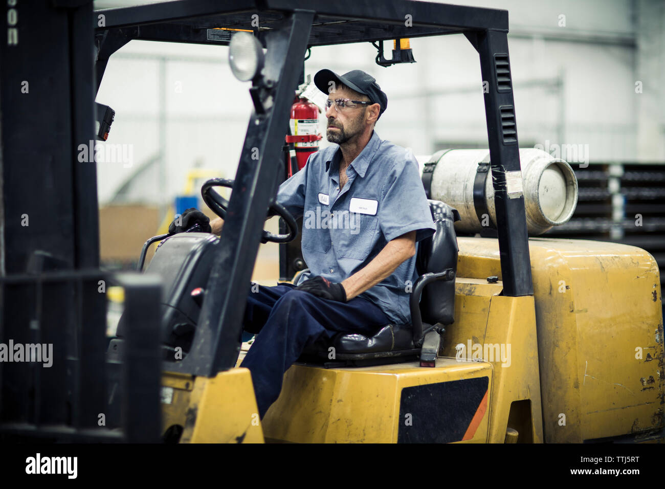 Ernste Arbeiter in Gabelstapler in der Metall Industrie sitzen Stockfoto