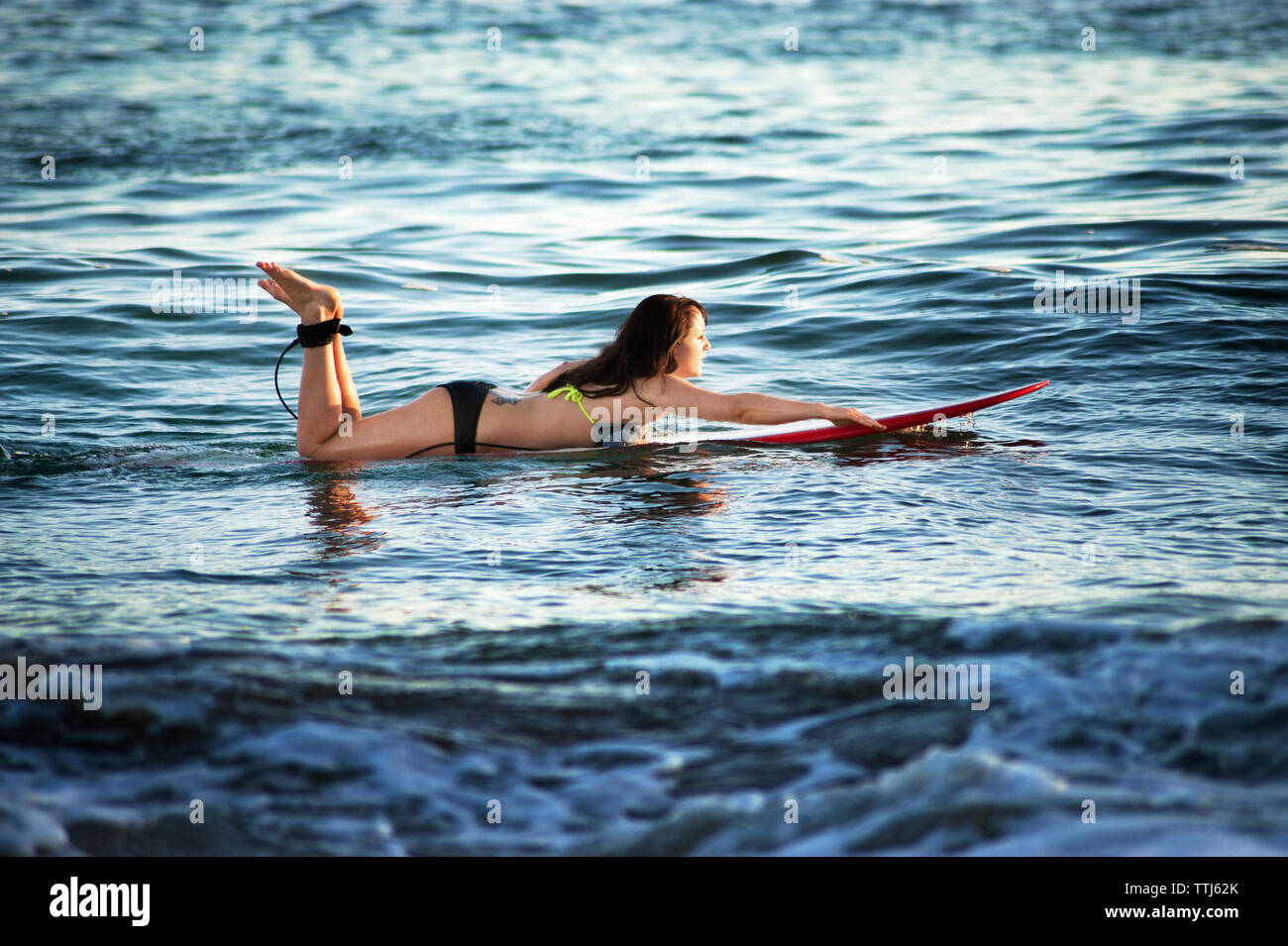 Seitenansicht der Frau Wellenreiten im Meer Stockfoto