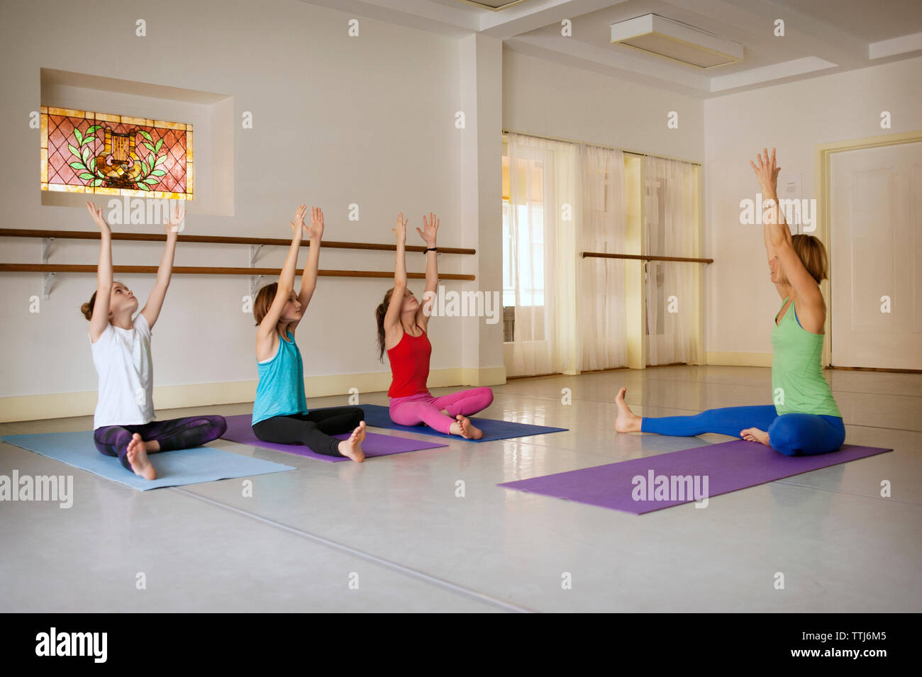 Trainer unterrichten die Kinder in Yoga class Stockfoto