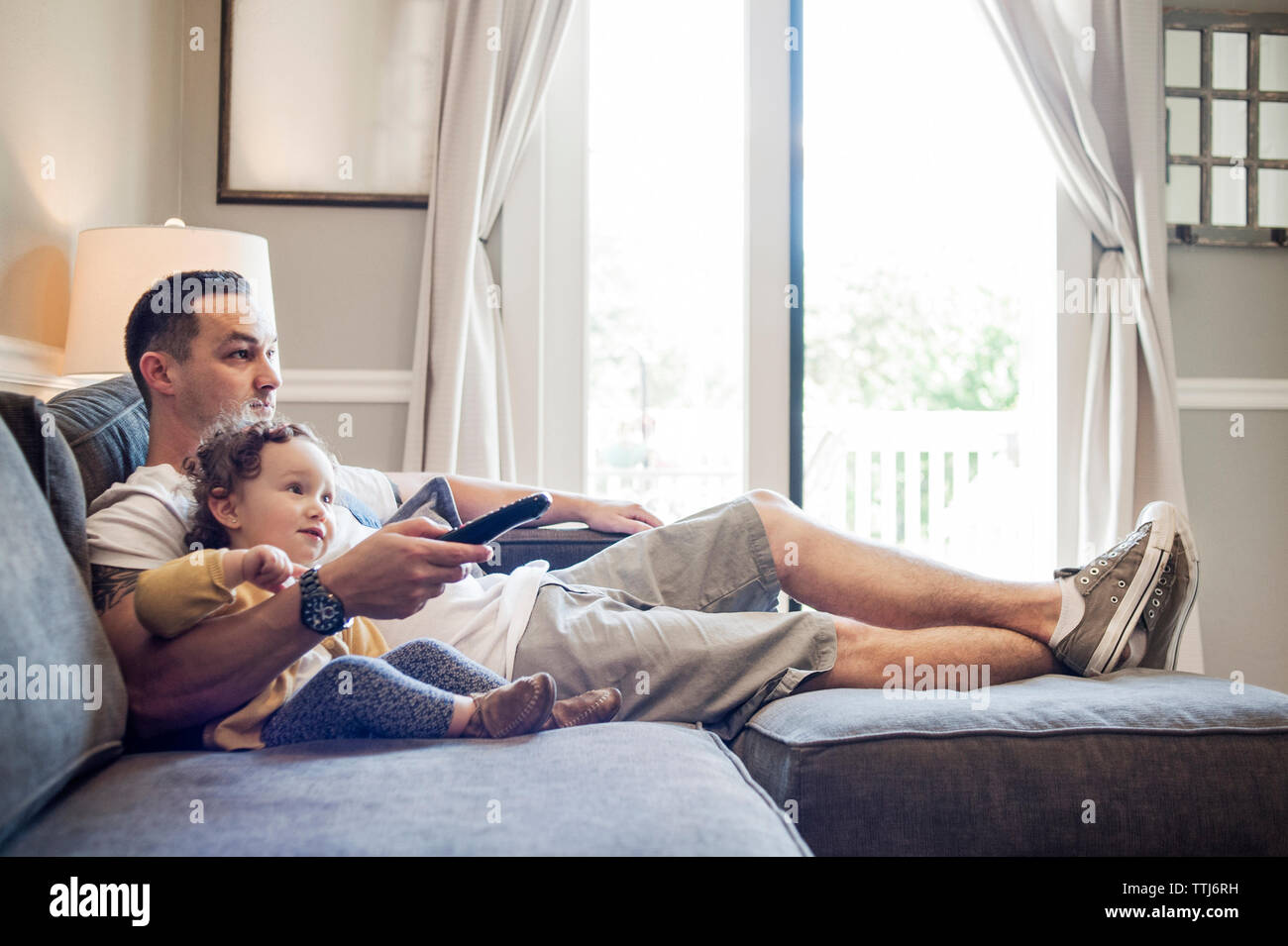 Vater und Tochter vor dem Fernseher zu Hause Stockfoto