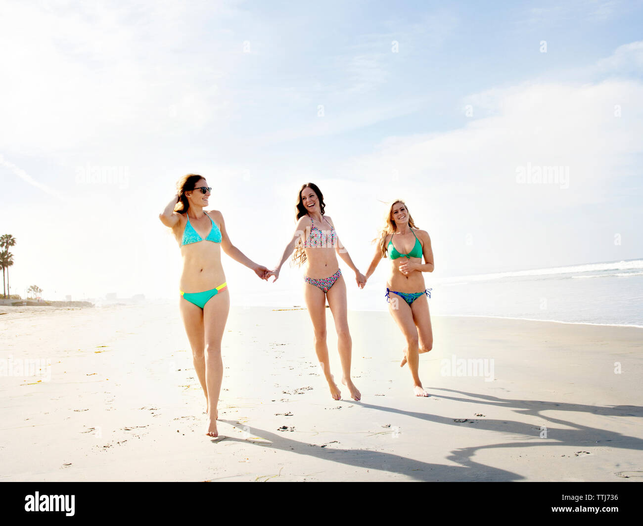 Gerne Freunde halten sich an den Händen beim Gehen auf Ufer am Strand Stockfoto
