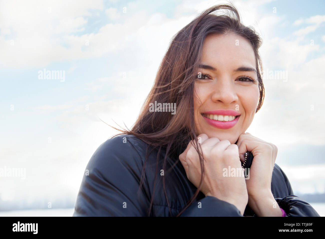 Portrait von Frau mit Händen Kinn gegen Sky Stockfoto