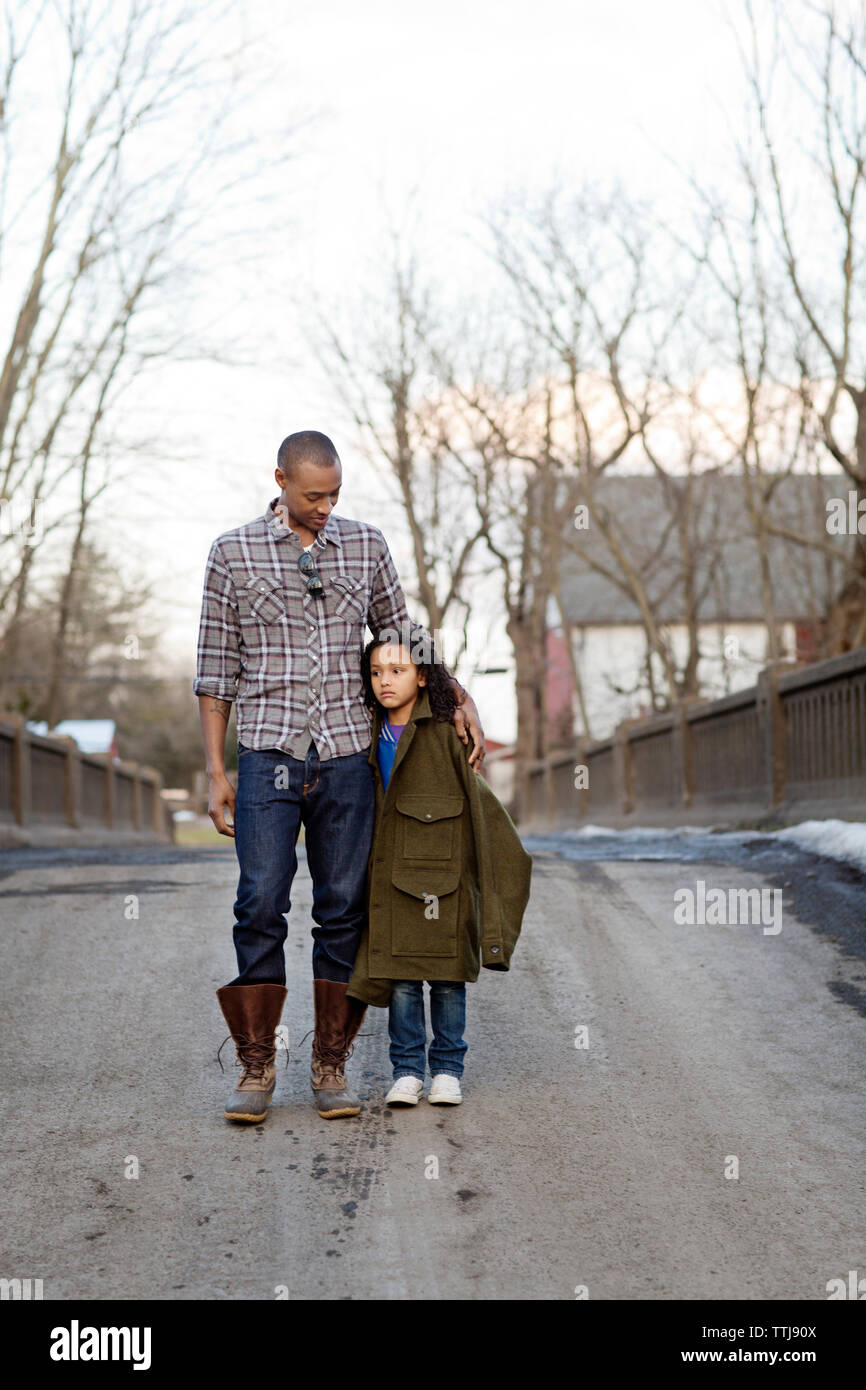 Vater auf traurige Tochter bei einem Spaziergang auf der Brücke gegen Sky Stockfoto