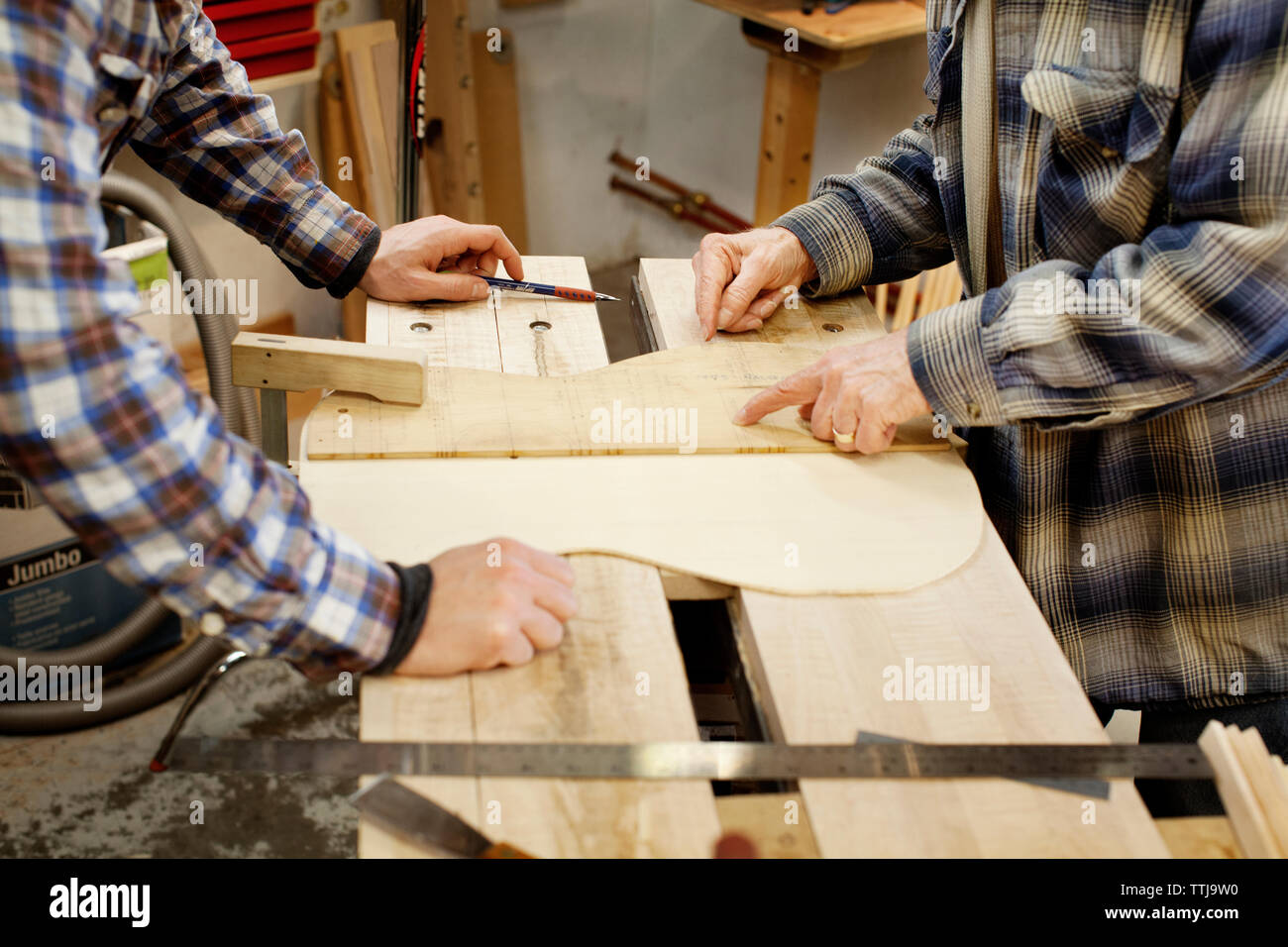 Zugeschnittenes Bild von Männern Herstellung Gitarren in der Werkstatt Stockfoto