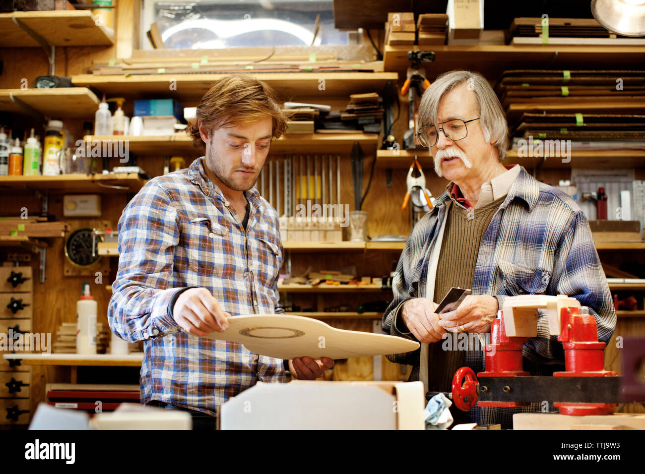 Vater und Sohn Herstellung Gitarre in Werkstatt Stockfoto