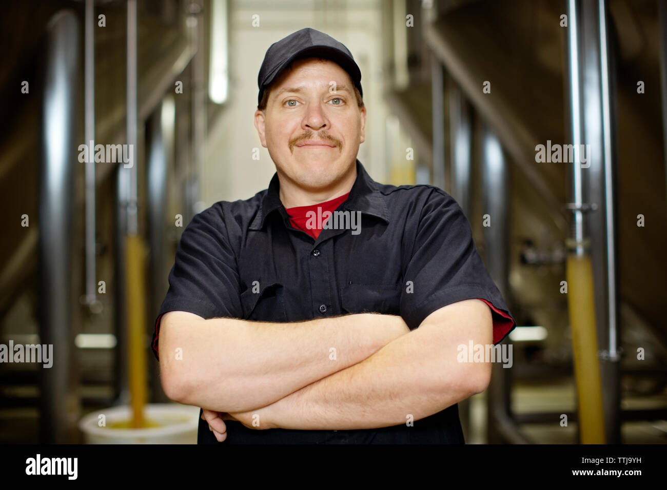 Portrait von sicher glücklicher Mann stehend an Brauerei Stockfoto