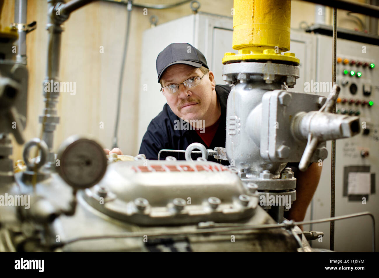 Porträt der Mann, der über die Maschinen an der Brennerei Stockfoto