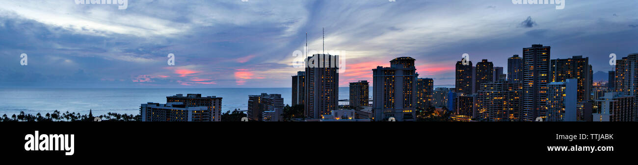 Panoramablick auf das beleuchtete Gebäude in der Stadt in der Dämmerung Stockfoto