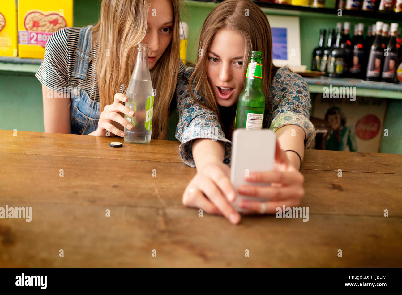 Freunde unter selfe und genießen Sie Drinks in Store Stockfoto