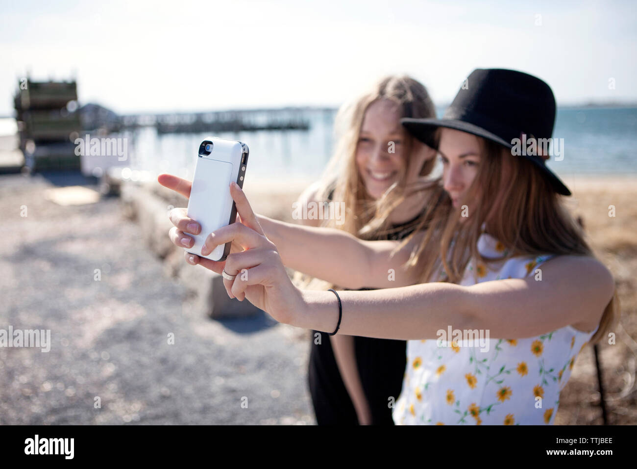Freunde von selfie während gegen Strand stehend Stockfoto