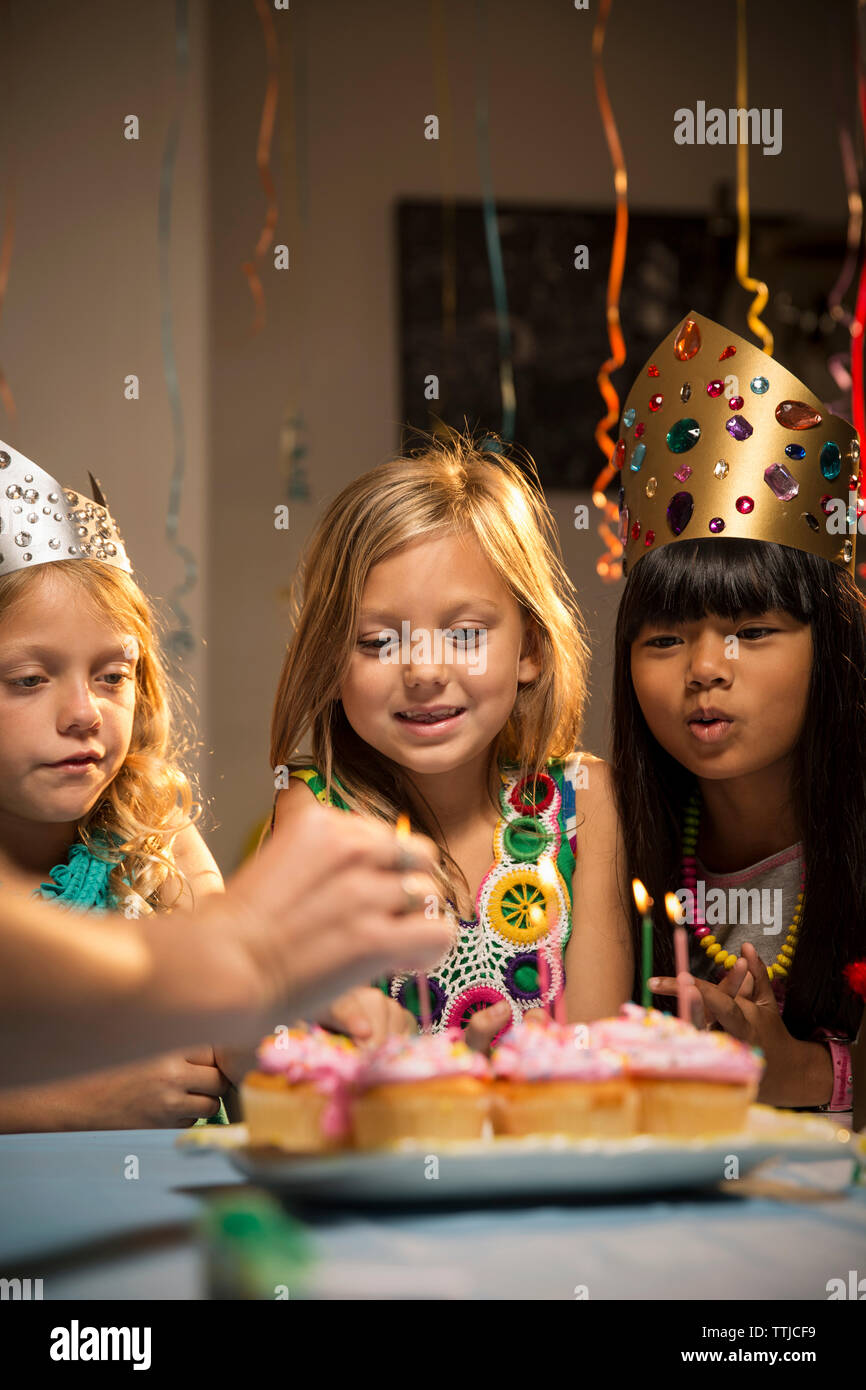 Lächelnd Freunde bei Cup Kuchen suchen während der Geburtstagsfeier Stockfoto