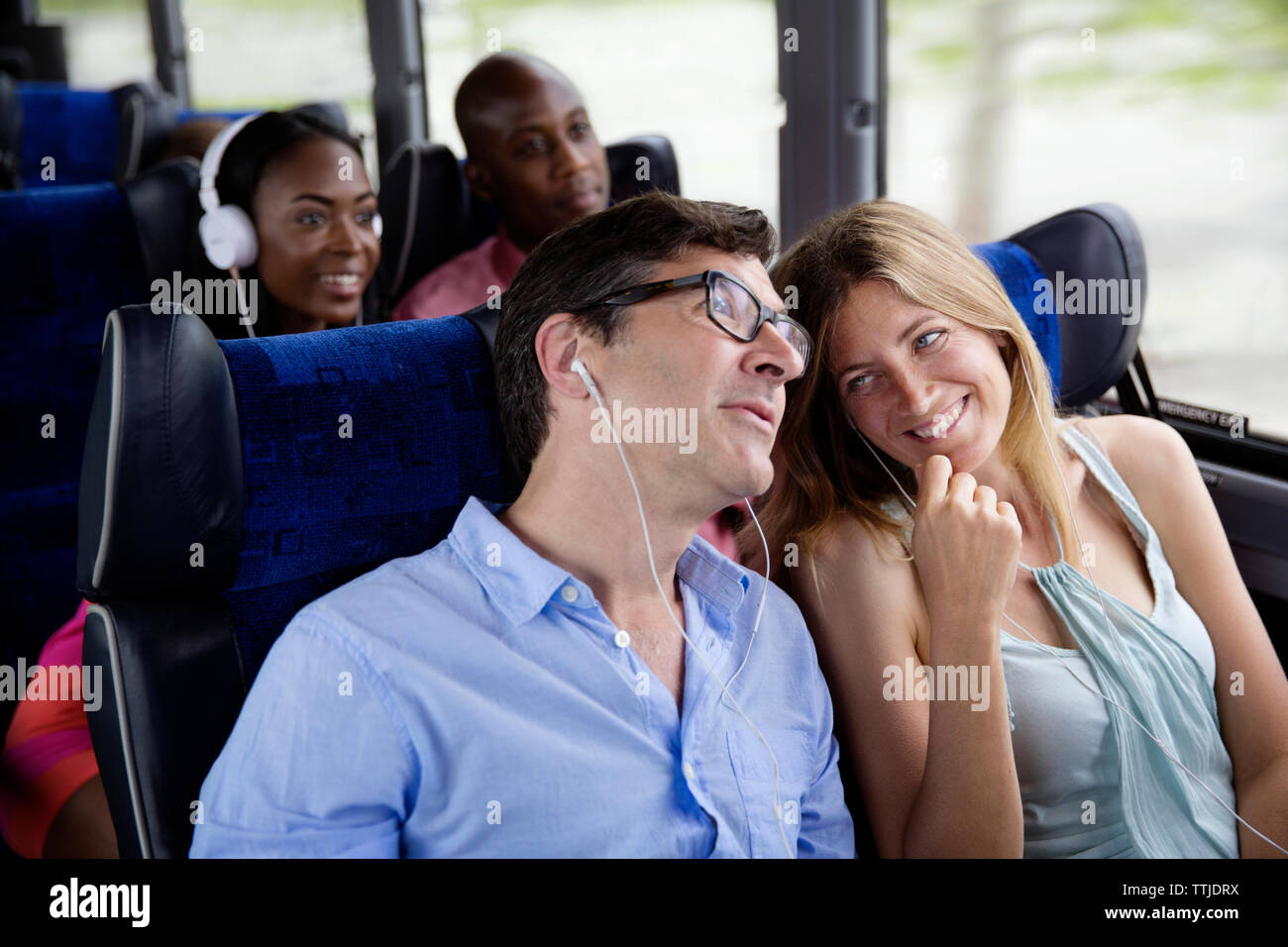 Glückliche Paare sitzen im Bus Stockfoto