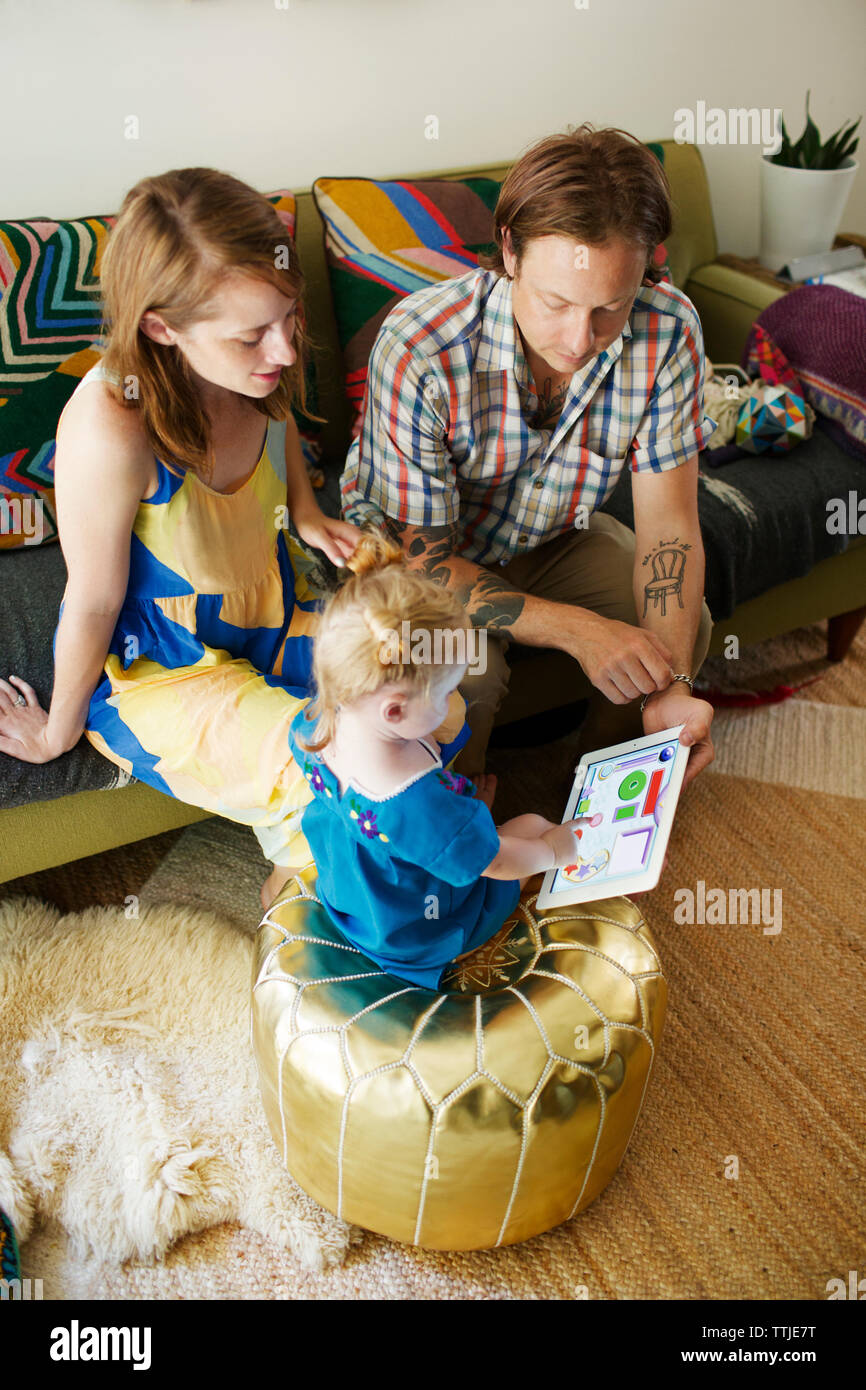 Hohe Betrachtungswinkel von Eltern zeigen Tablet Computer Baby Mädchen zu Hause Stockfoto