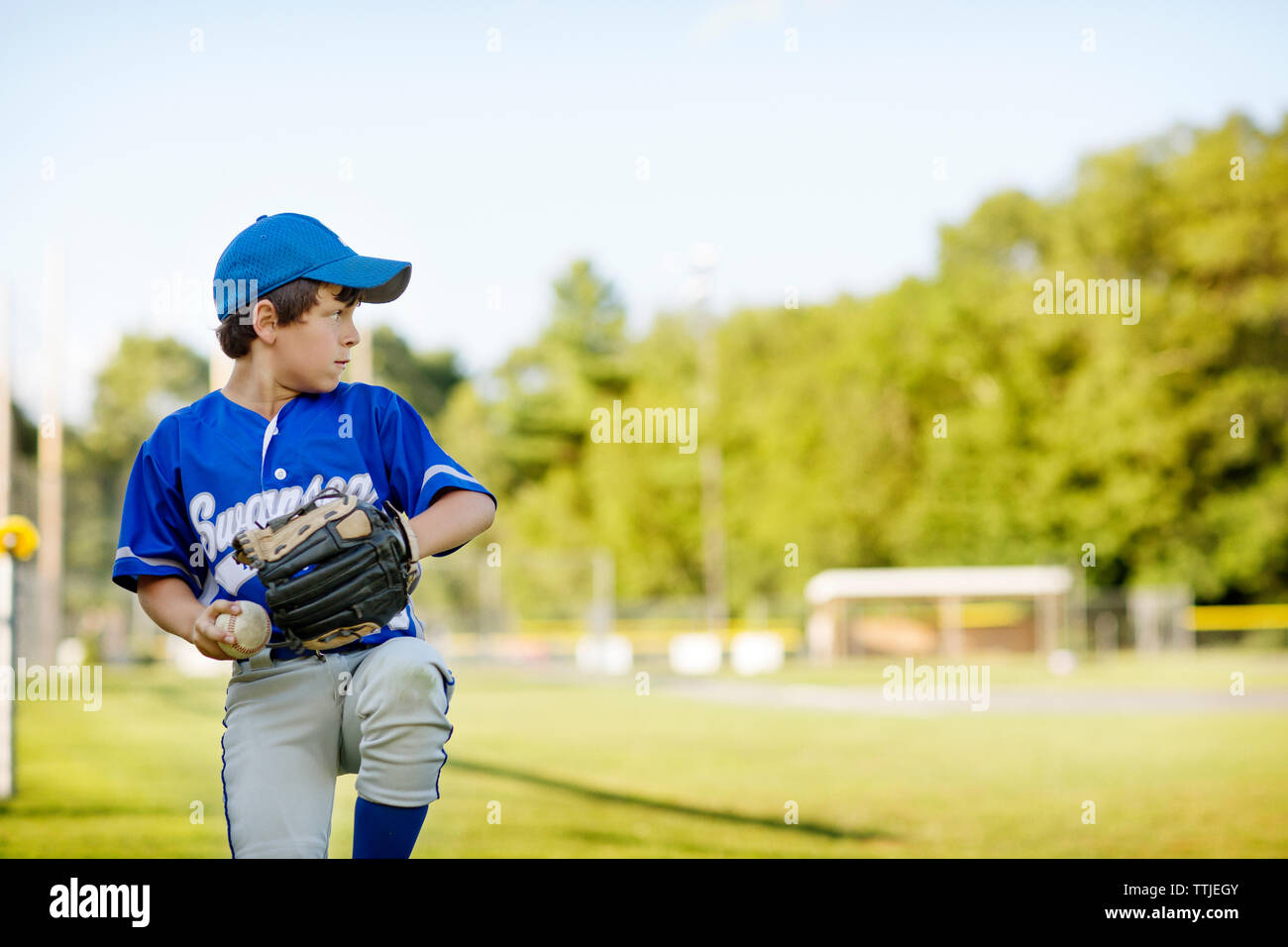 Junge spielt Baseball auf Feld Stockfoto