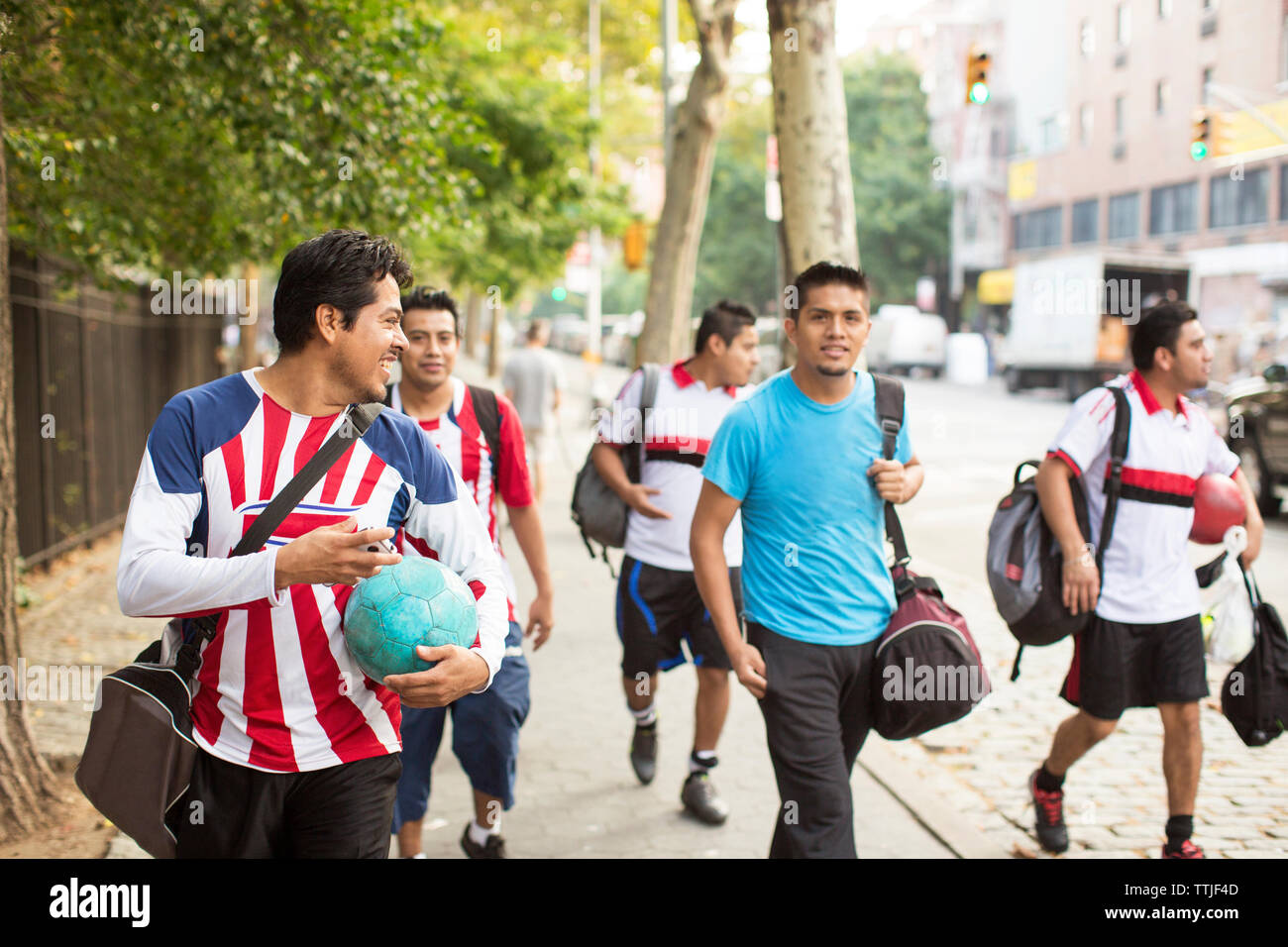 Gerne Fussball Spieler zu Fuß auf Fußweg Stockfoto
