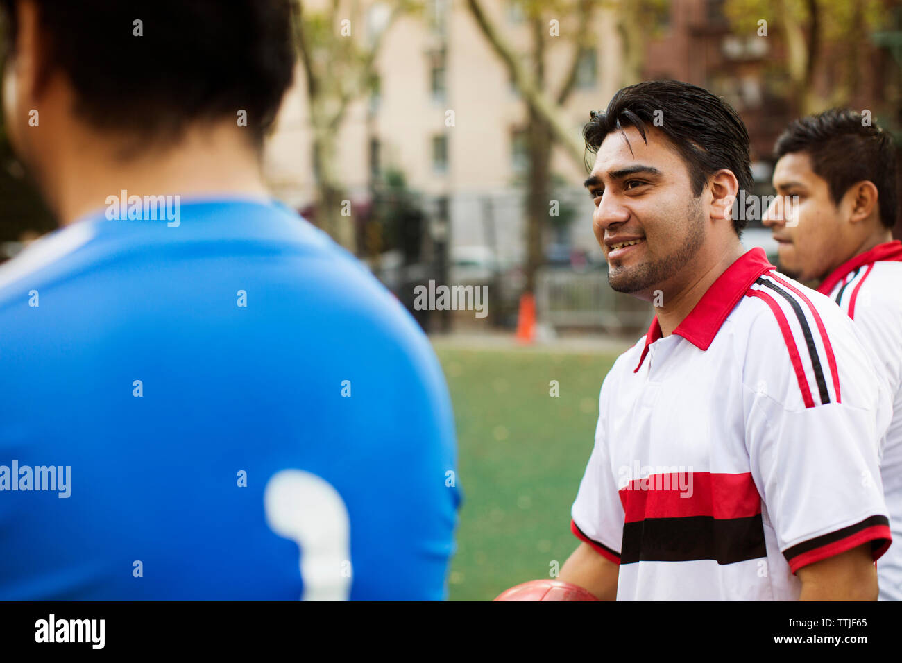 Der Mensch auf der Suche beim Stehen, die von den Spielern am Feld Stockfoto
