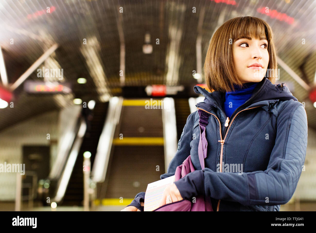 Frau schaut über die Schulter beim Stehen in der Nähe der U-Bahn Station Stockfoto