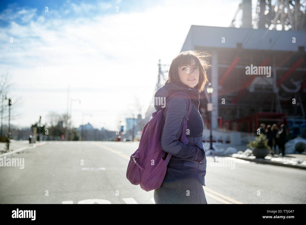 Frau mit Hand in der Tasche weg schauen beim Stehen auf der Straße Stockfoto