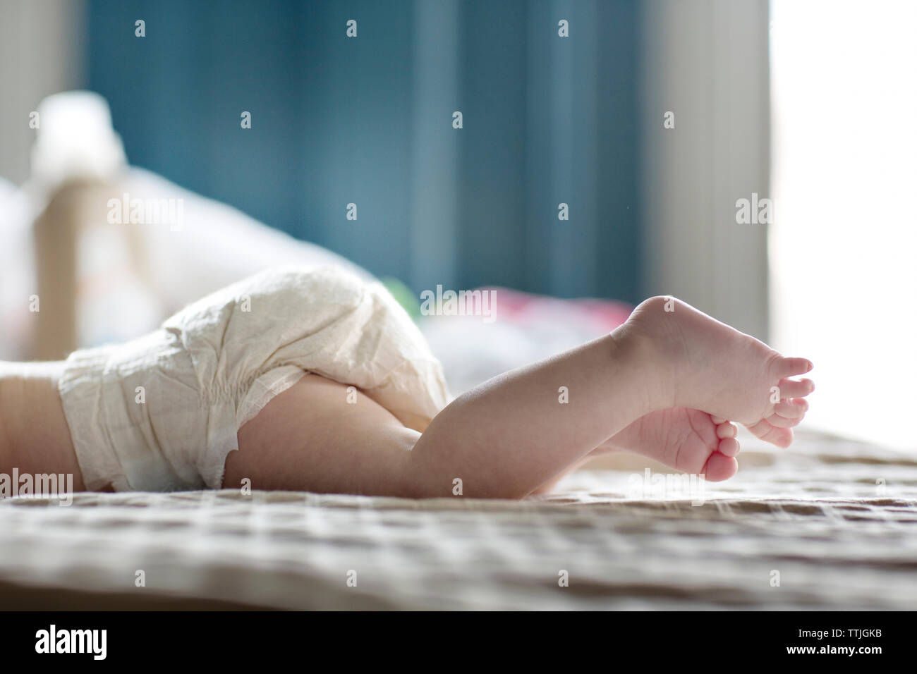 Niedrige Abschnitt von Baby Mädchen liegt auf dem Bett zu Hause. Stockfoto