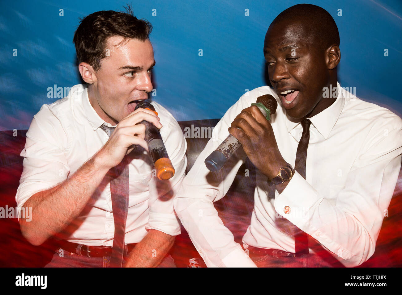 Freunde singen Karaoke in Nachtclub Stockfoto