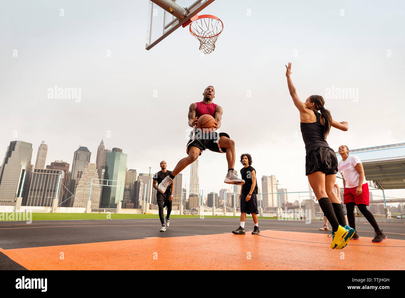 Athleten Basketball spielen vor Gericht gegen Gebäude Stockfoto