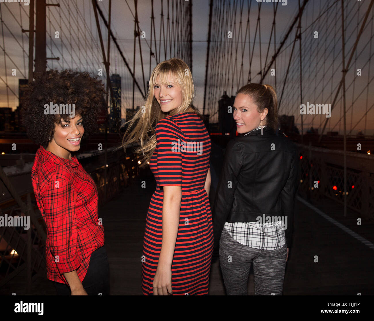 Die Frauen, die über die Schulter beim gehen auf der Brooklyn Bridge Stockfoto