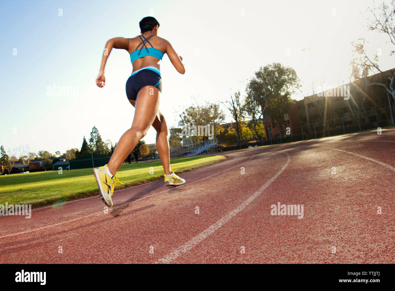 Frau läuft auf Sport track gegen Sky Stockfoto