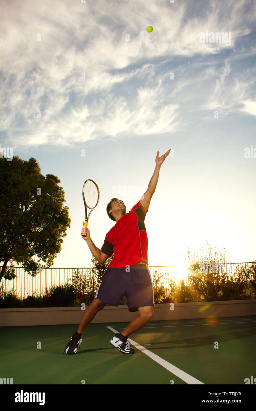 Mann spielt Tennis im Feld gegen Sky Stockfoto