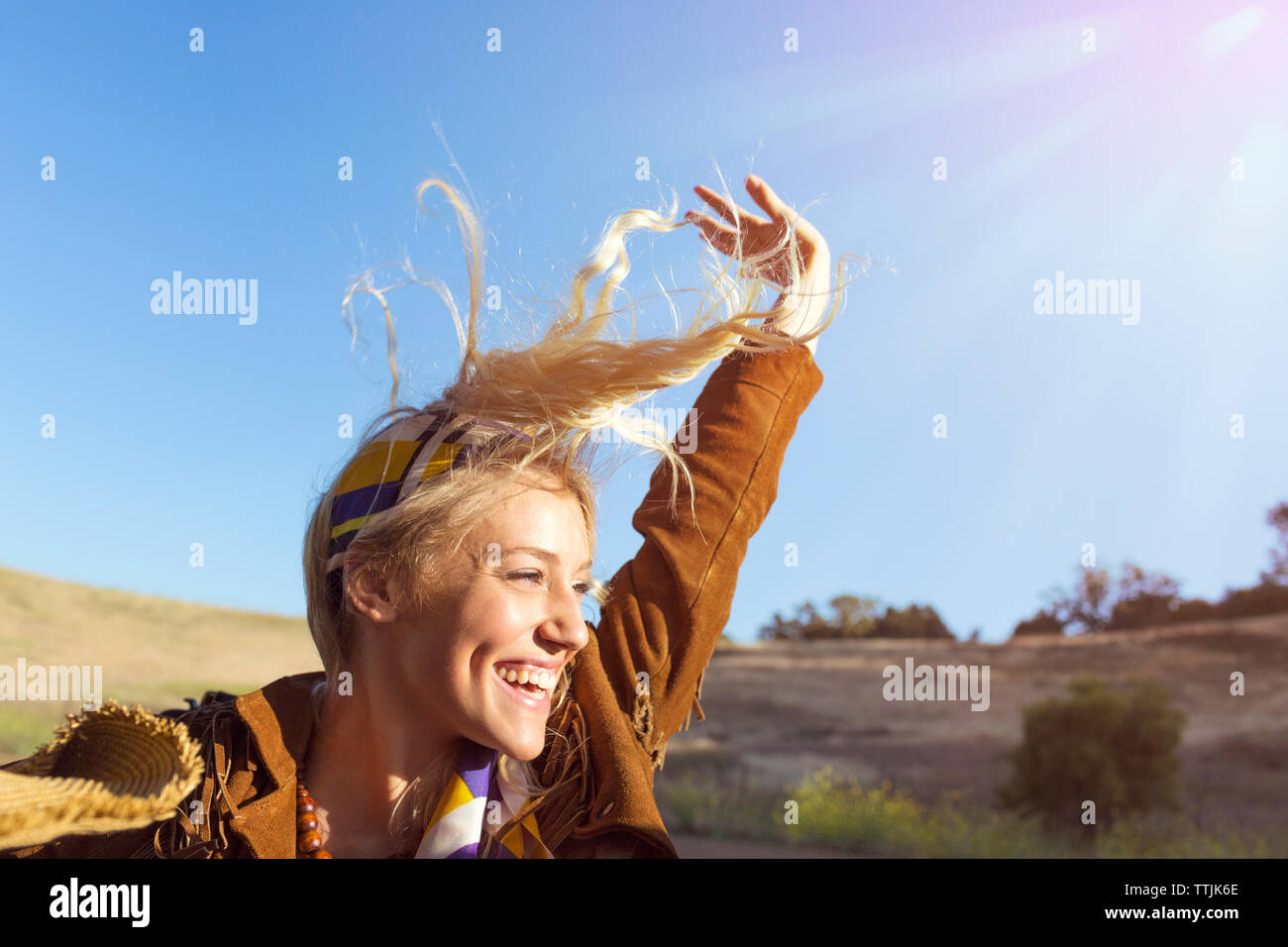 Fröhliche Frau mit Arm gegen den klaren Himmel angehoben Stockfoto