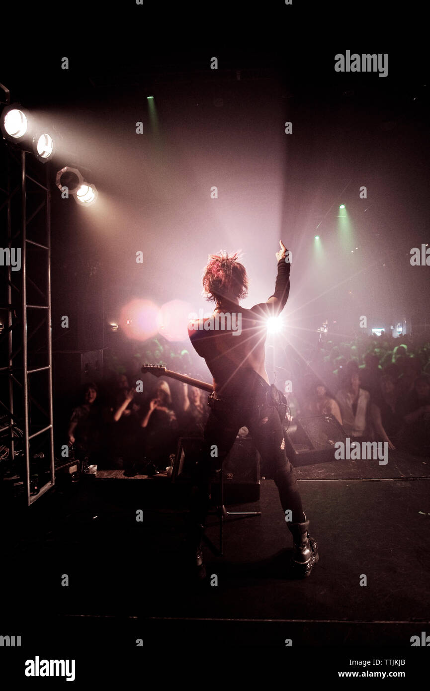Rückansicht des Menschen mit Arm angehoben durchführen bei Konzert Stockfoto