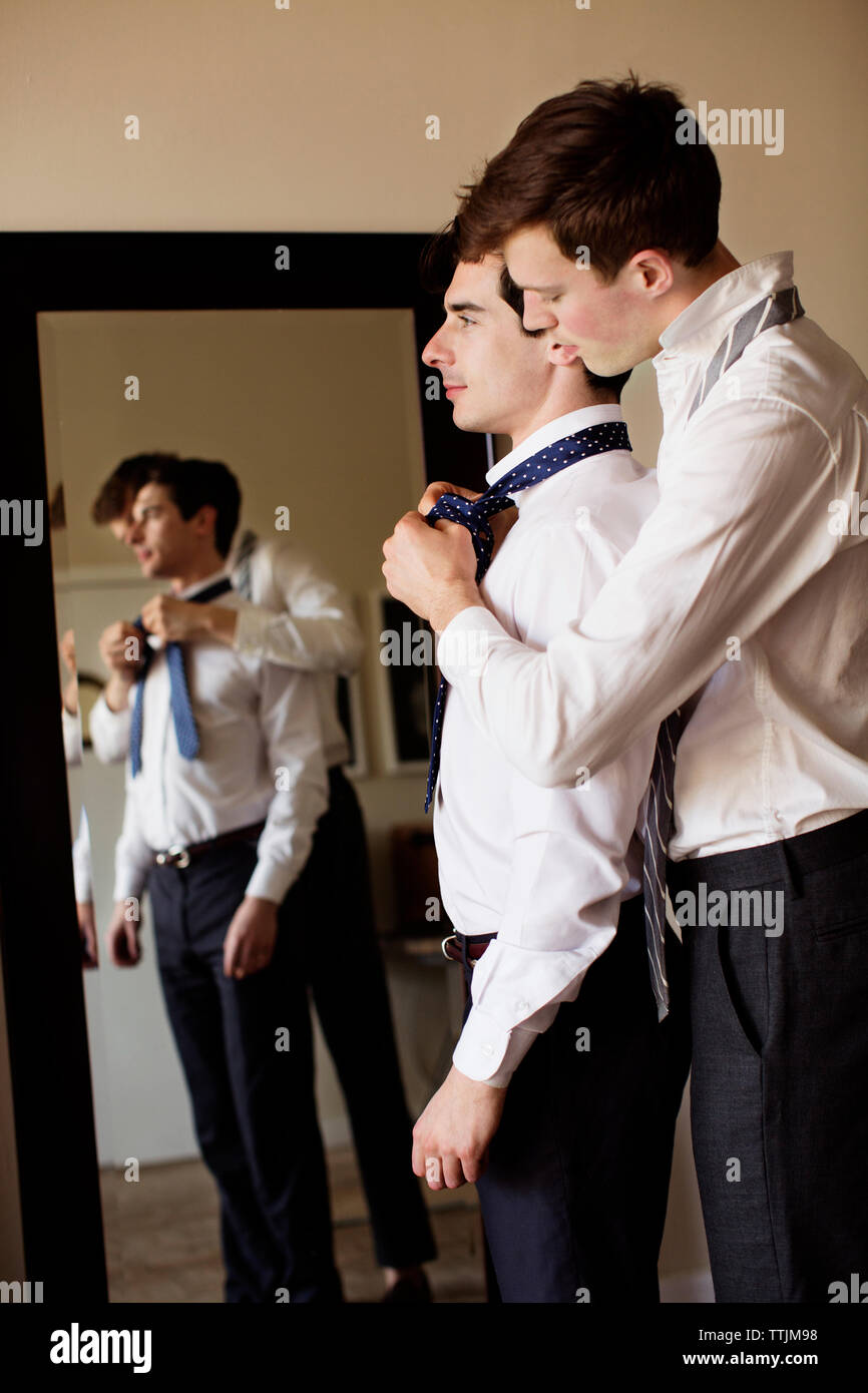 Seitenansicht des homosexuellen Mann Unterstützung Freund für das Binden der Krawatte Stockfoto