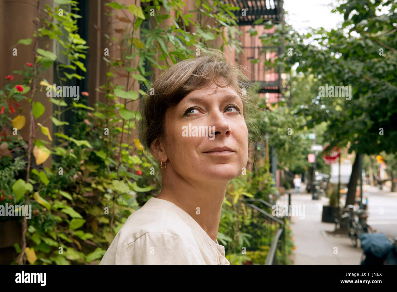 Frau weg, während sich gegen Gebäude in der Stadt Stockfoto