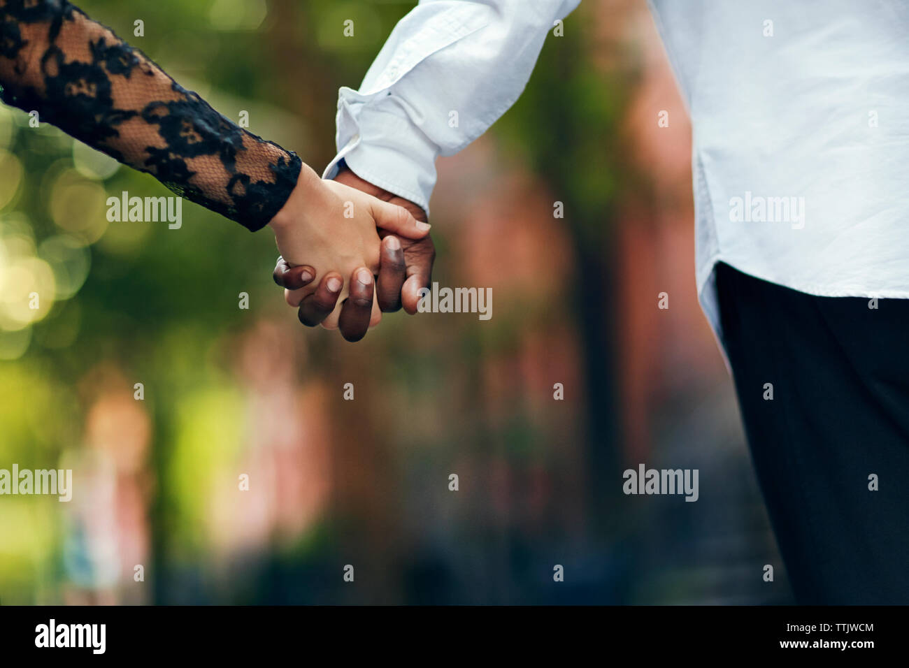 Image der jungen Paar Hand in Hand auf der Straße 7/8 Stockfoto