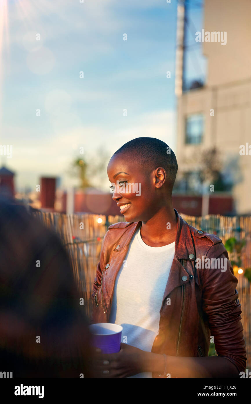 Lächelnde Frau mit Getränk während der Partei Stockfoto