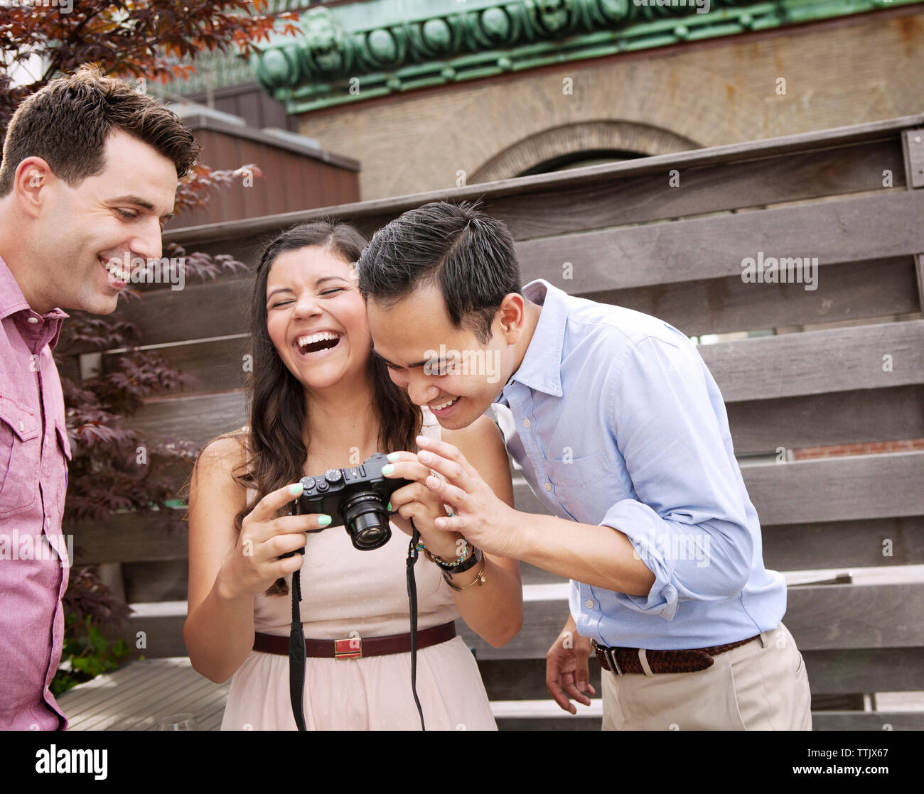 Gerne Freunden in die Kamera, während gegen Holz Wand Stockfoto