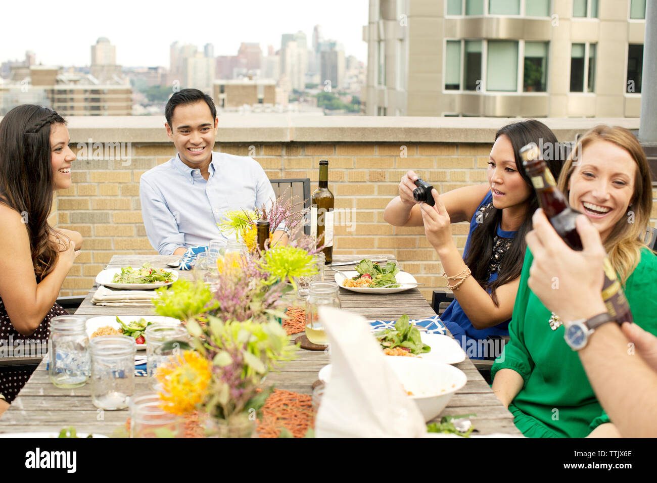 Gerne Freunde genießen Sie Ihre Mahlzeit auf der Terrasse Gebäude in der Stadt Stockfoto