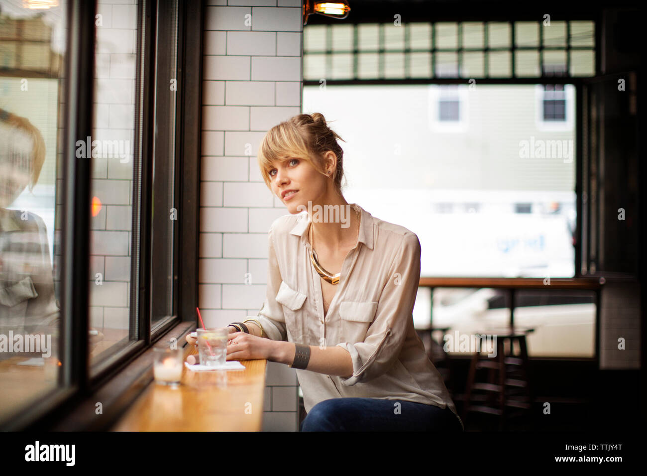 Frau weg, beim Sitzen auf Hocker in bar Stockfoto