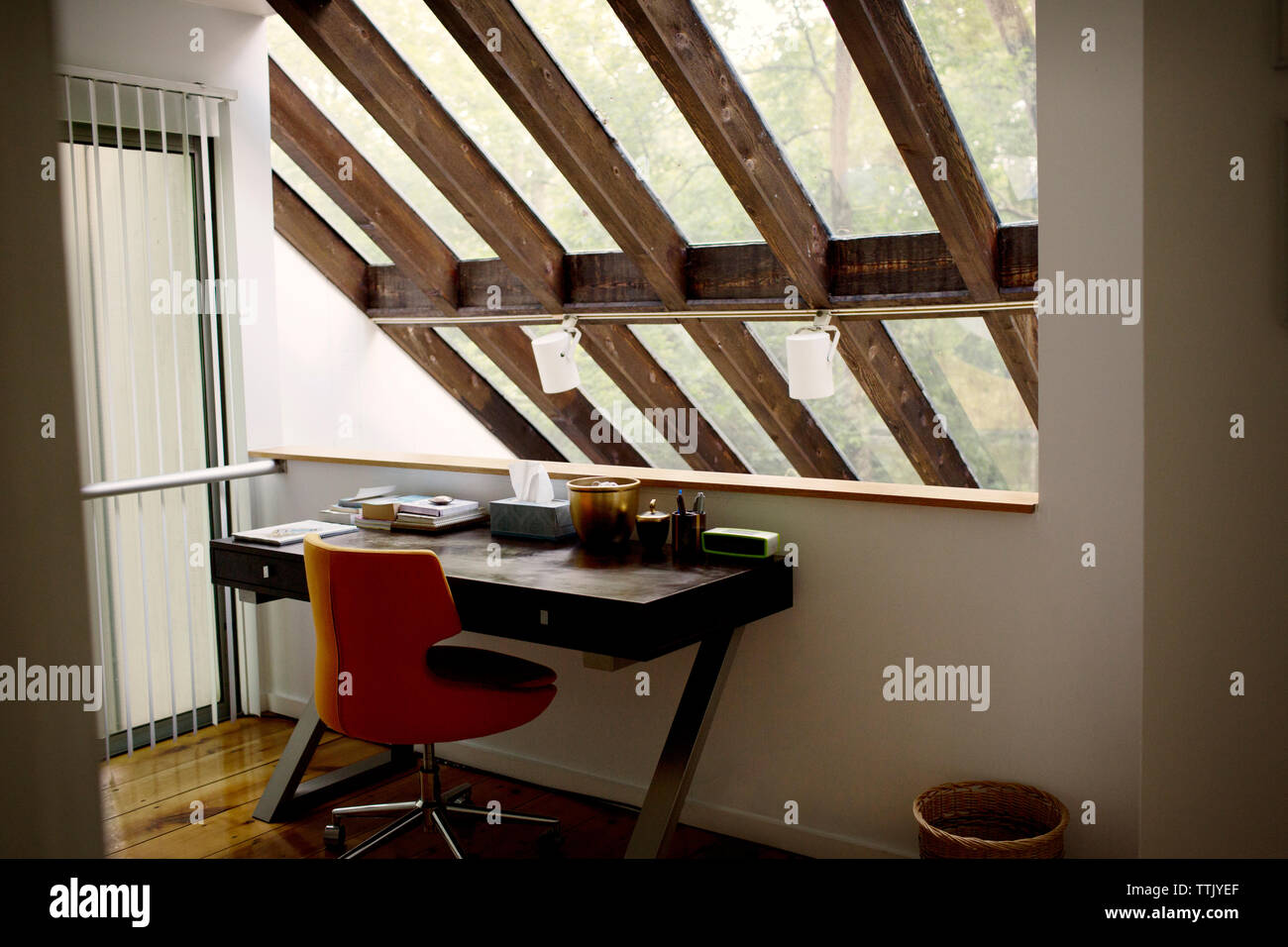 Tisch und Stuhl von Mauer gegen Dach zu Hause angeordnet Stockfoto