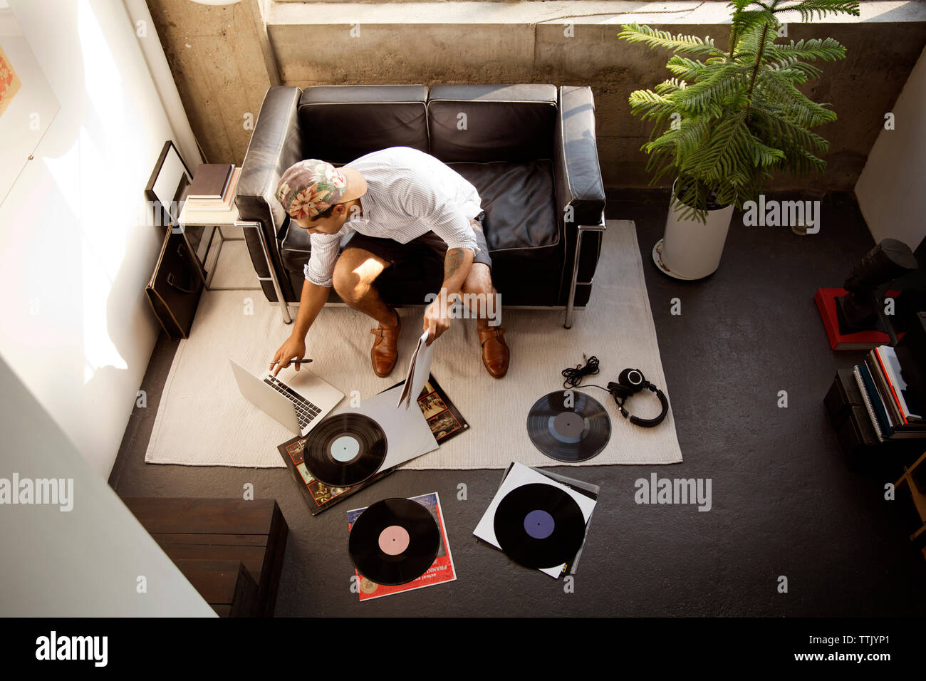 Hohe Betrachtungswinkel des Musikers mit Laptop während der Arbeit von Platten zu Hause Stockfoto