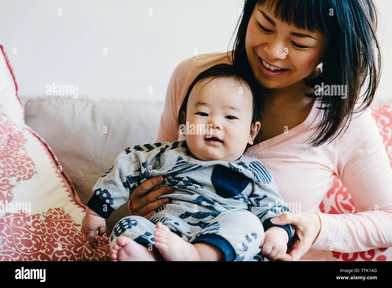 Glückliche Mutter mit niedlichen Sohn sitzen auf einem Sofa zu Hause Stockfoto
