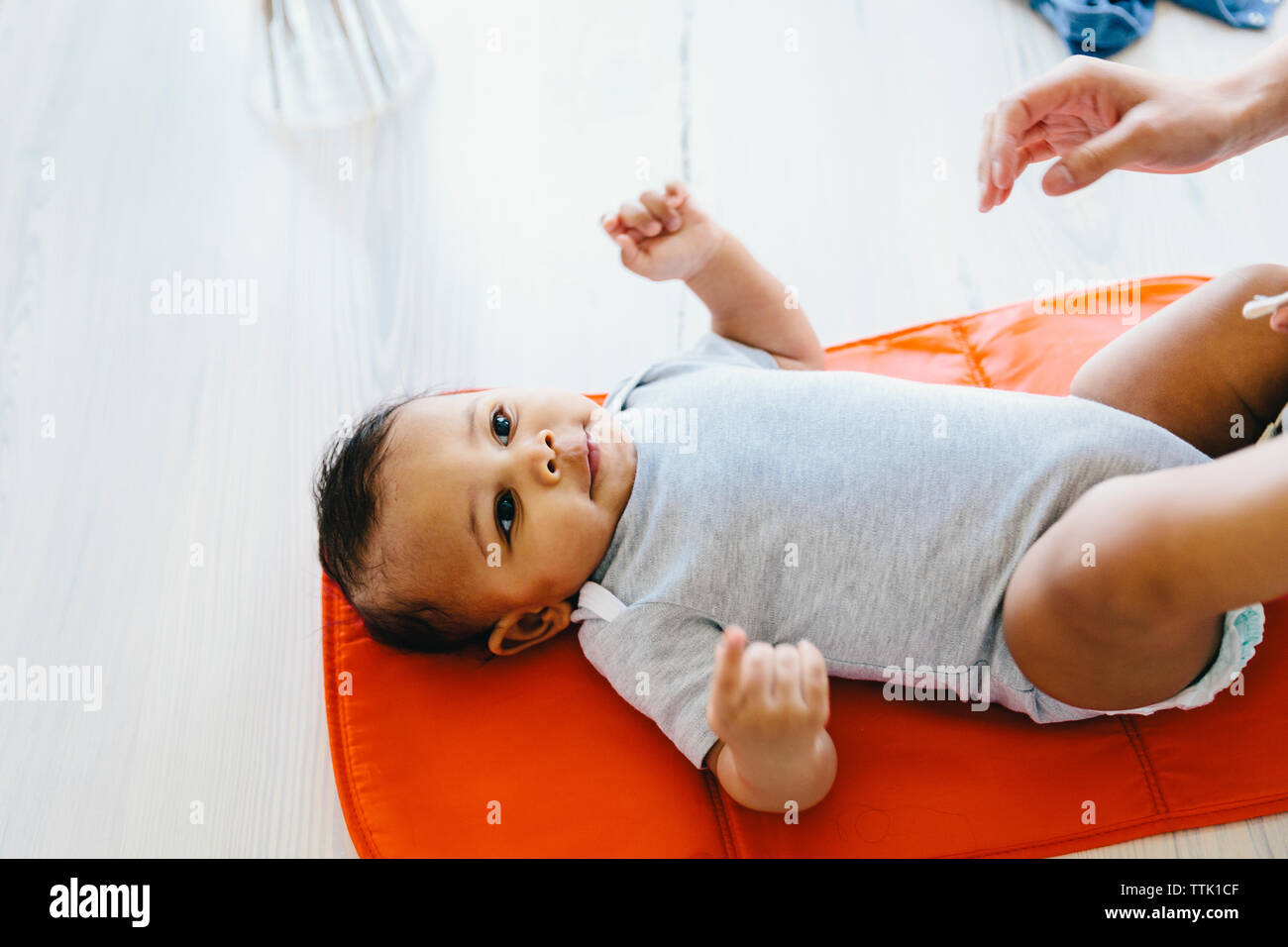 7/8 Hand der Mutter erreichen in Richtung Son liegen auf Babydecke zu Hause Stockfoto