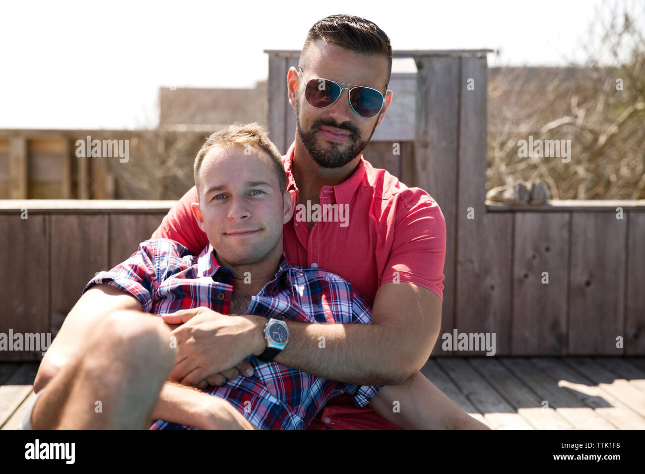 Portrait von homosexuelle Paare sitzen auf der Promenade gegen den klaren Himmel Stockfoto