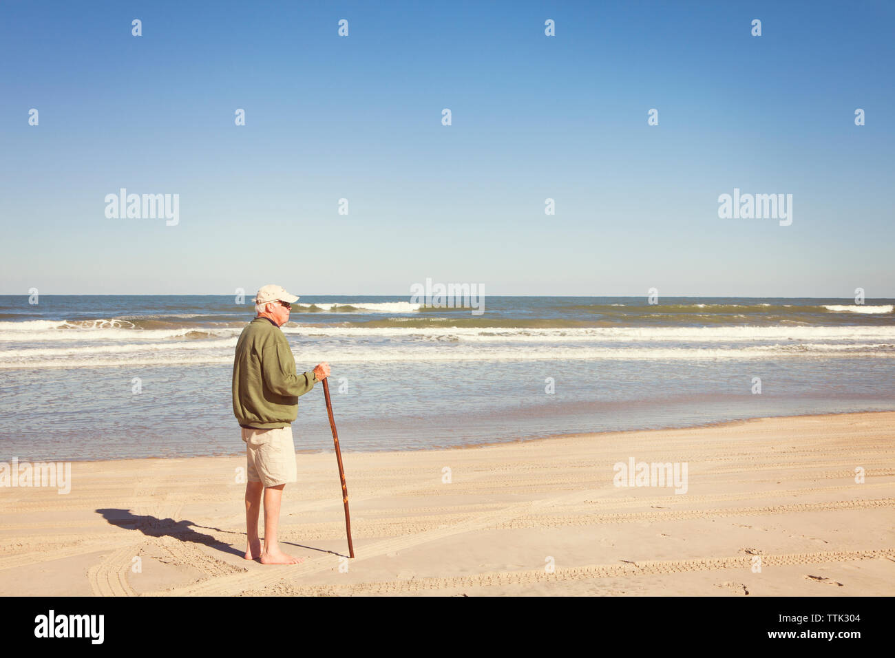 Seitenansicht der älteren Mann stand am Ufer am Strand Stockfoto